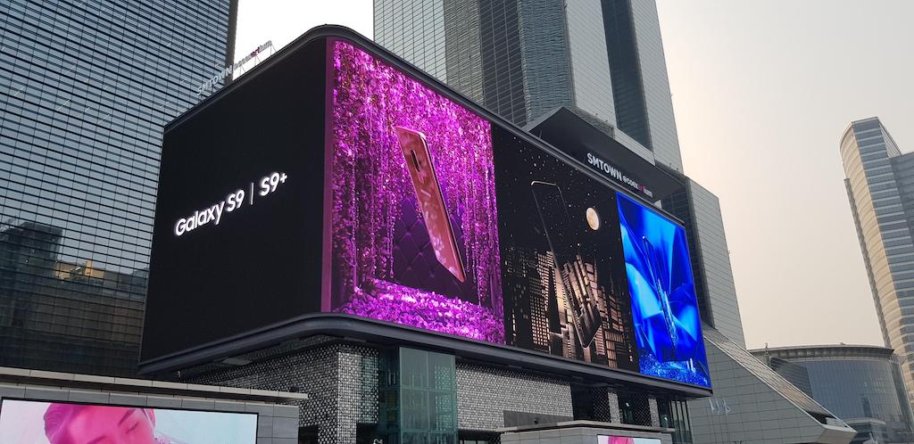 High-impact corner outdoor LED screen on a building by Visual Lab, delivering dynamic advertising content and strong visual presence in public urban spaces.شاشة إل إي دي خارجية عالية التأثير على زاوية مبنى من فيجوال لاب، تقدم محتوى إعلاني ديناميكي وحضور بصري قوي في المساحات الحضرية.