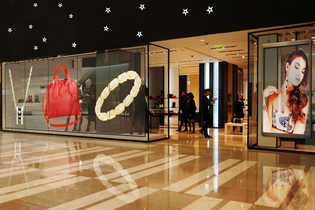Transparent LED storefront display by Visual Lab showcasing a luxury ring product advertisement with dynamic visuals and high-impact retail marketing.شاشة إل إي دي شفافة على واجهة متجر من فيجوال لاب تعرض إعلان خاتم فاخر بمحتوى بصري ديناميكي وتسويق تجزئة عالي التأثير.