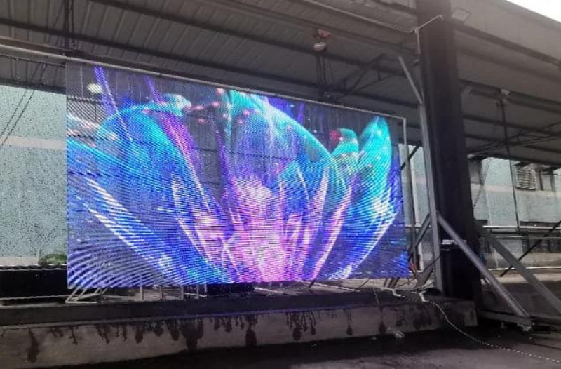 Suspended transparent LED display at an event by Visual Lab, delivering immersive digital visuals and high-impact presentation for exhibitions and live shows.شاشة إل إي دي شفافة معلقة في فعالية من فيجوال لاب، تقدم محتوى بصري غامر وعرضاً رقمياً عالي التأثير في المعارض والعروض الحية.