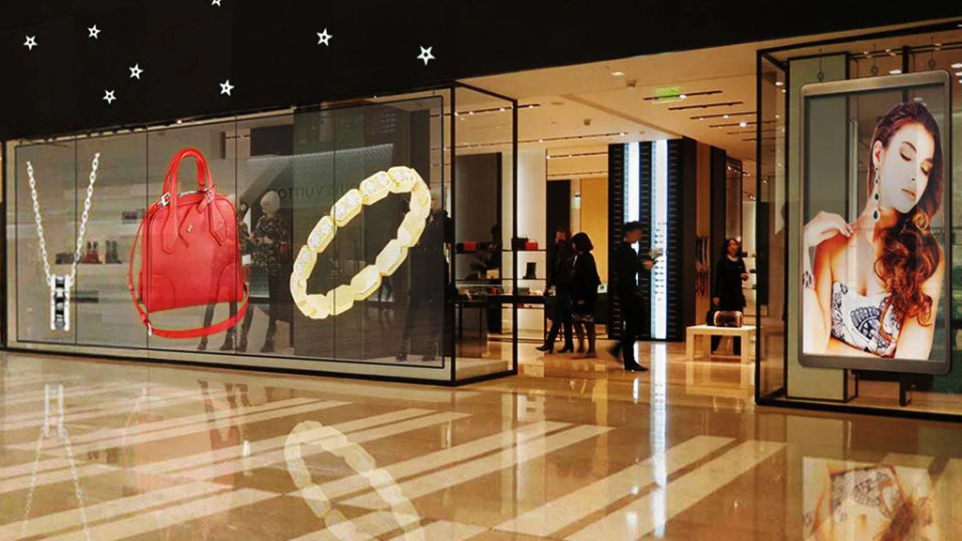 Transparent LED storefront display by Visual Lab showcasing a luxury ring product advertisement with dynamic visuals and high-impact retail marketing.شاشة إل إي دي شفافة على واجهة متجر من فيجوال لاب تعرض إعلان خاتم فاخر بمحتوى بصري ديناميكي وتسويق تجزئة عالي التأثير.